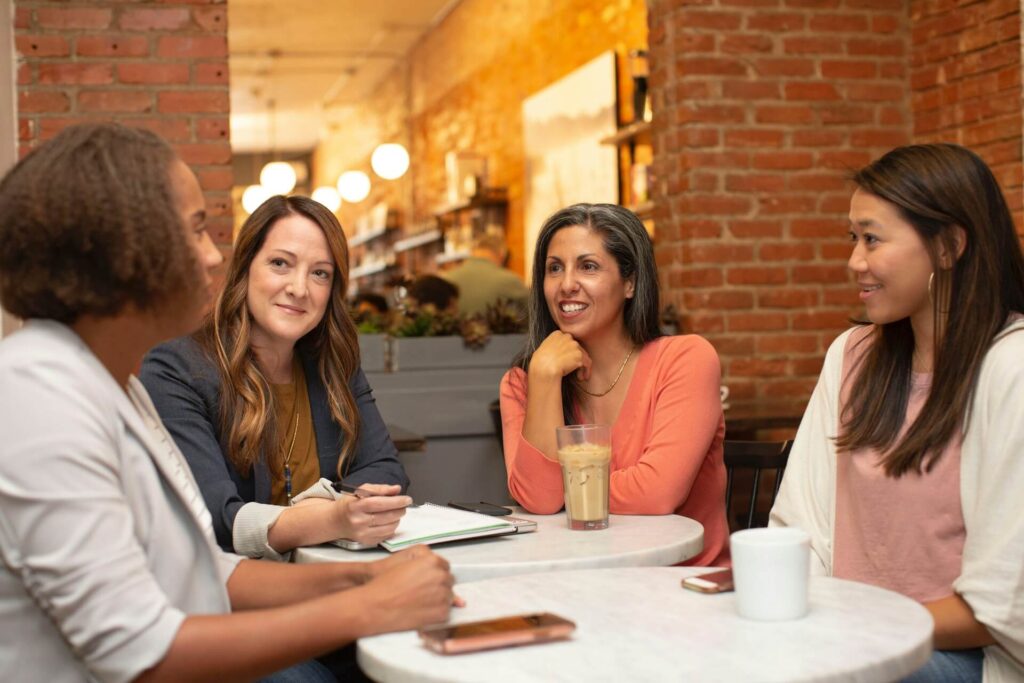 Four women in a business meeting around a table